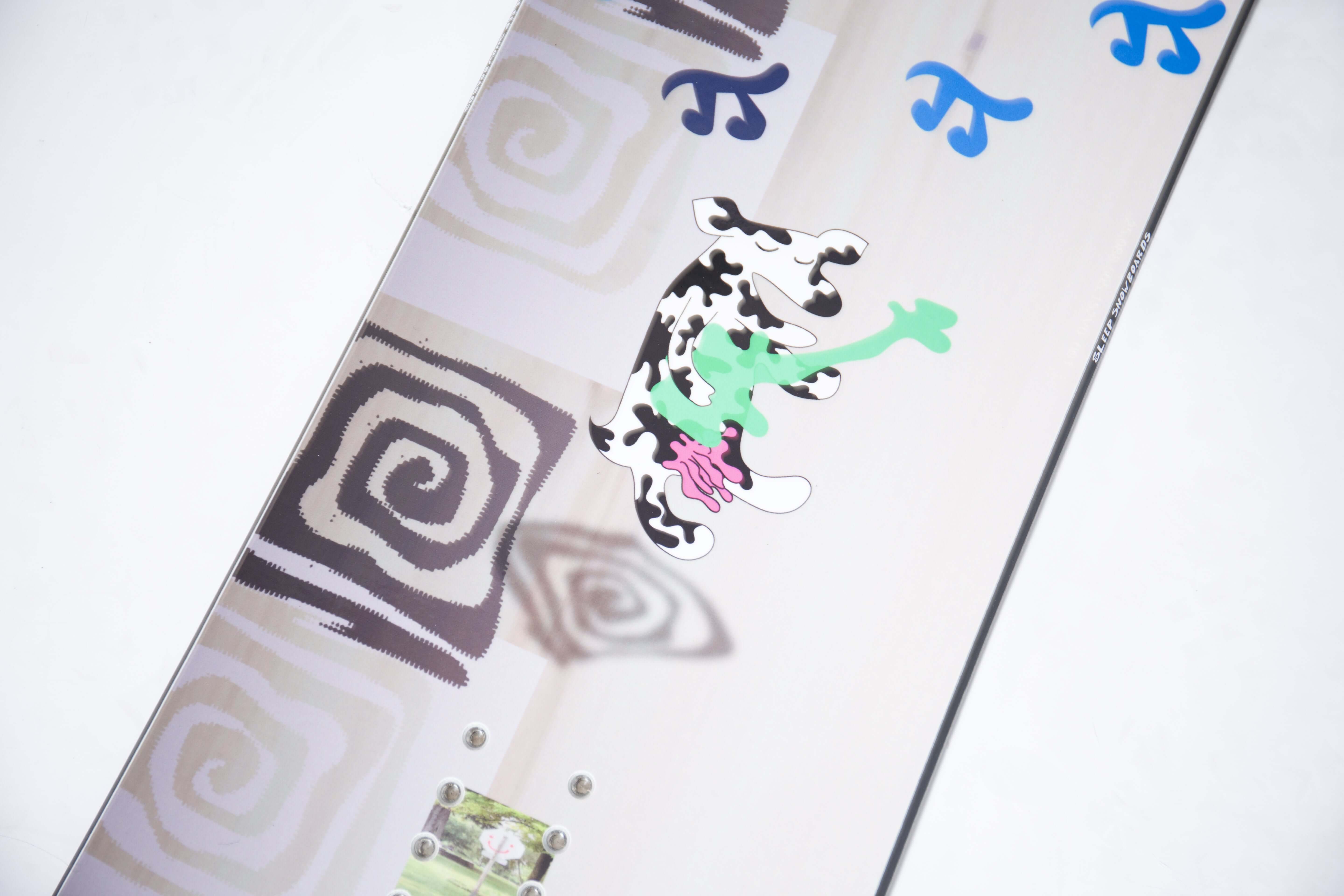 Close-up of the Humble Pi Snowboard's unique graphic design featuring abstract patterns and vibrant colors from Sleep Snowboards.